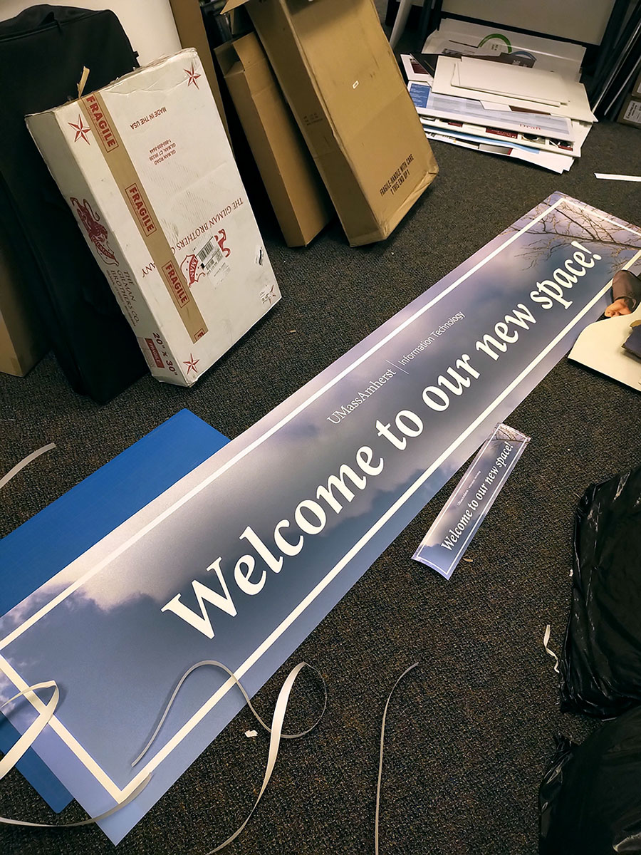 a giant banner in production in a tiny amount of floor space in an office