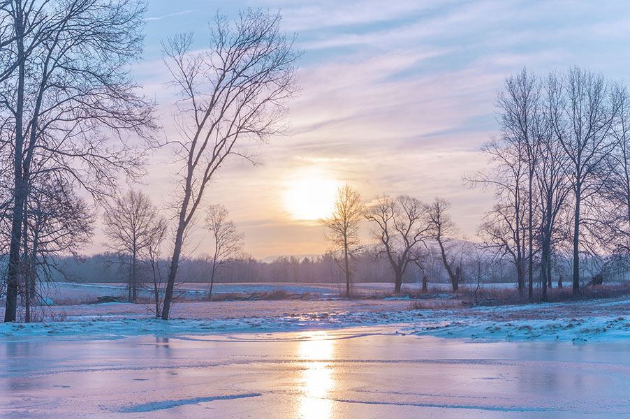 a pink and cyan early morning sunrise on an icy winter day
